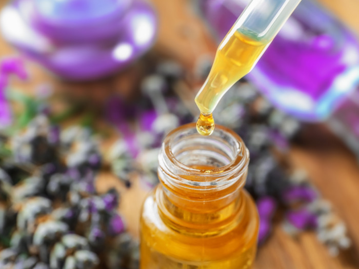 Lavender essential oil drop bottle with a blurred background